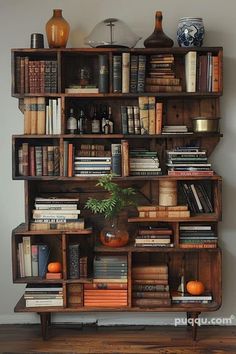 a bookshelf filled with lots of books on top of a wooden floor next to a wall