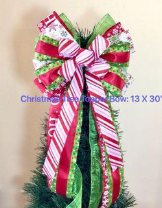 a christmas tree decorated with red, green and white ribbons