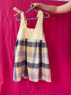 One-of-a-kind dress with shoulder ties made from a mix of yellow plaid flannel fabric, and a thicker cotton blue and yellow plaid. Adjustable top with ties to be worn loose or tight. Gathered skirt for fun twirling. Size: Medium, but can fit a small if straps are tied tighter. Fabric Care: No need to handwash, unless you really want to. Don't let me stop you! All cotton fabric can be ironed and is okay to be thrown in the dryer. Cotton Plaid Sundress, Cotton Plaid Dress For Summer, Cotton Plaid Dress For Picnic, Sleeveless Cotton Plaid Dress For Picnic, Cotton Plaid Dress For Picnics, Casual Sleeveless Cotton Plaid Dress, Casual Cotton Plaid Dress For Picnic, Casual Yellow Dresses With Tie Straps, Casual Yellow Dress With Tie Straps