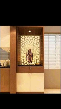 a buddha statue sitting on top of a wooden shelf next to a window with blinds