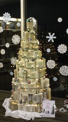 a christmas tree made out of rolls of wrapping paper in front of a window with snowflakes on the windowsill