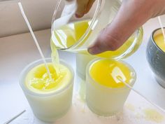 two glasses filled with yellow liquid being poured into them