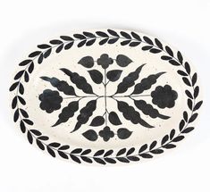 a black and white plate with leaves on it