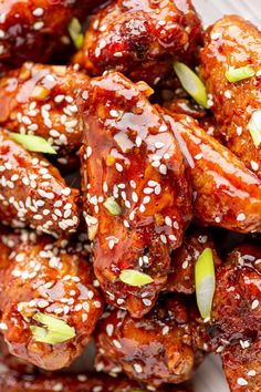 sesame seed chicken wings are piled on top of each other