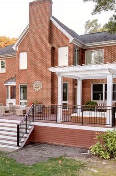 a large brick house with a deck and patio