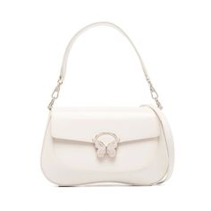 a white handbag with a butterfly on the front and shoulder strap, sitting on a white