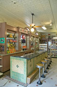 the inside of a grocery store with lots of counter tops and stools in it