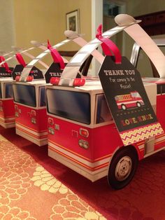 a row of firetrucks with thank you tags on them sitting on a table