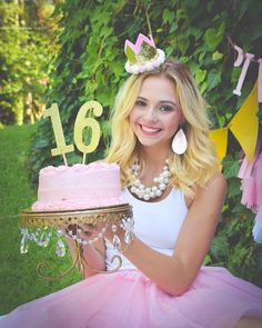 a woman sitting in front of a cake with the number sixteen on it and wearing a tiara