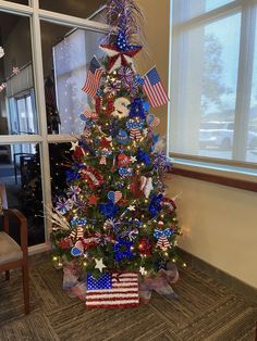 a decorated christmas tree with red, white and blue decorations in the shape of american flags