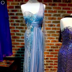 two dresses on mannequins in front of a brick wall with blue and purple sequins