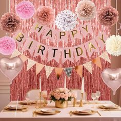 a birthday party with pink, gold and white decorations on a table in front of a backdrop that says happy birthday