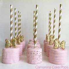 pink cake pops with gold and white striped candles