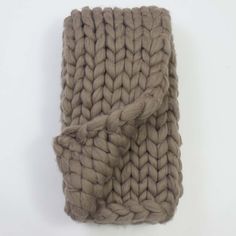 a brown knitted blanket sitting on top of a white table