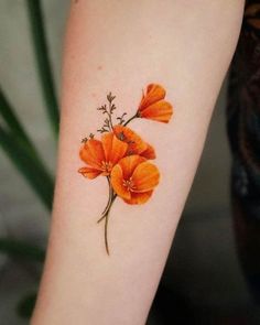 an orange flower tattoo on the arm