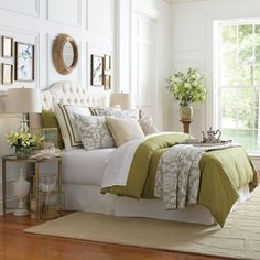 a bedroom with white walls and green bedding