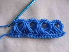 a crochet hook with blue yarn next to it