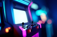 an old fashioned video game with neon lights on the screen and two arcade machines behind it