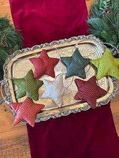 five star ornaments in a silver tray on a table