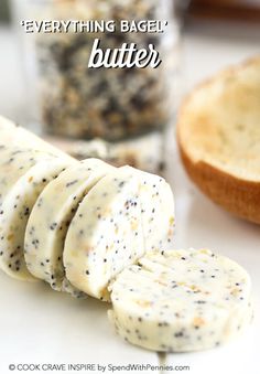 everything bagel butter is cut into pieces and placed on a table with bread in the background