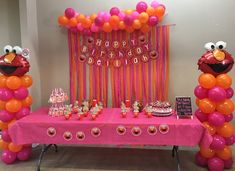 a pink table topped with lots of balloons next to an orange and pink dessert bar