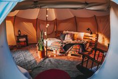 a bed in a tent with pillows and blankets