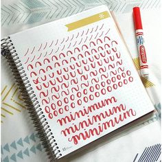 a notebook with some writing on it next to a red marker and an orange pen