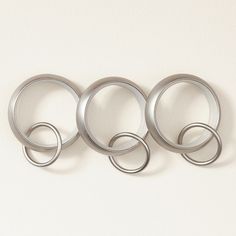 four metal rings are hanging on the wall