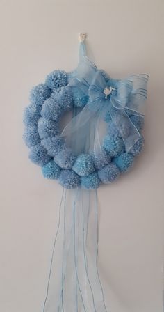 a blue wreath hanging on the wall next to a white wall with some string attached to it