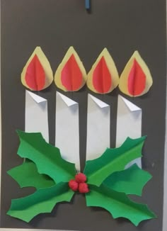 an origami christmas card with candles and holly