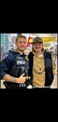 two men standing next to each other wearing police uniforms