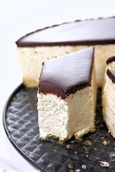 two pieces of cake sitting on top of a black plate with one slice cut out