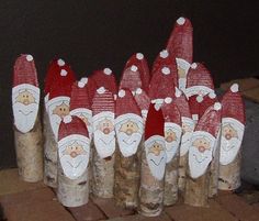 there are many wooden santa clause decorations on the tree stumps that have been made to look like santa's hats