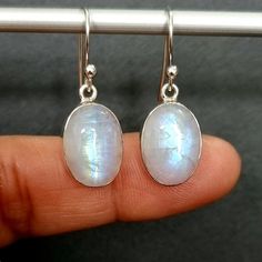 💖  Product Description Large Rainbow Moonstone Oval Earrings set in 925 Sterling Silver.  Moonstone is the June Birthstone. The hues and iridescence will vary from pair to pair and the ones in the photos, so please do contact us prior to purchasing if you would like to see the exact pair you will receive 💖 Product Details *  925 Sterling Silver *  Handmade *  Total Drop from top of Earring to base  - 30mm *  Width at Widest point - 10mm *  Stone Size - 14mm x 10mm *  Depth of Stone - 7mm *  Weight - 4.5g 💖  Packaging All items come in a pretty little gift bag made from Recycled saris.  If your earrings are a gift, then please do advise of colour preferences and we will do our best to send out a colour of choice.  For gemstone earrings, we do try and match the colour of the bag with the White Oval Moonstone Earrings, Silver Gemstone Oval Pendant Earrings, Handmade Oval Moonstone Earrings, Oval Moonstone Earrings For Gift, Oval Silver Gemstone Earrings, Oval Earrings, Oval Earring, Moonstone Earrings, June Birthstone