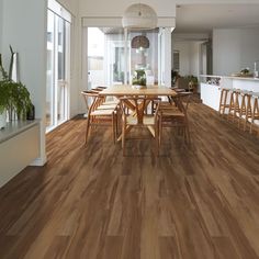 a large dining room with wooden floors and white walls, along with an open floor plan