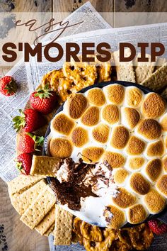 a dessert plate with s'mores dip and strawberries on the side next to crackers