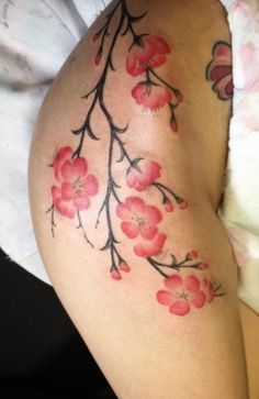 a woman's thigh with red flowers on it