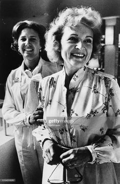 two women standing next to each other smiling