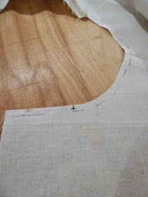 an unfinished piece of fabric sitting on top of a wooden table