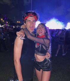 a man and woman standing next to each other at a music festival