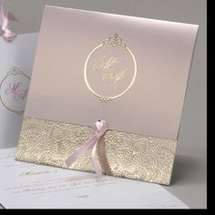 a pink and gold wedding card with a ribbon