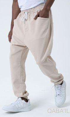 QL Relaxed Cotton STRETCH Cuffed Trousers in Beige Description:QL Relaxed Cotton Stretch Cuffed Trousers offer a perfect balance of laid back, chic and sporty styles! Straight cut harem pants with ultra soft and very elastic stretch cotton fabric. Very comfortable and flexible, it allows you to be free to move while being stylish! Modern Islamic clothing for men High-quality fabric from top brands Logo on the back pocket and ribbed cuffs Two side patch pockets and two back patch pockets Elastic Beige Stretch Tapered Leg Bottoms, Beige Stretch Bottoms With Tapered Leg, Beige Straight Leg Bottoms For Streetwear, Baggy Beige Bottoms For Loungewear, Cream Pants With Pockets For Streetwear, Sporty Relaxed Fit Beige Bottoms, Beige Tapered Leg Lounge Pants, Beige Wide Leg Sweatpants For Streetwear, Beige Wide-leg Sweatpants For Streetwear