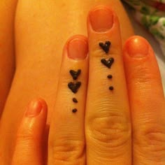 two people with matching tattoos on their fingers