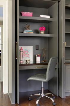 a chair sits in front of a desk with bookshelves and shelves on it