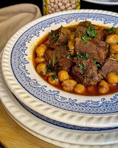 a blue and white plate topped with meat and beans