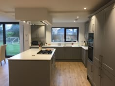 a kitchen with an oven, stove and dining room table in the backround