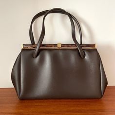 Description: Vintage Brown Leather Tortoishell Detail Top Handle  Handbag  Measurementsstrong>Width: 33cm, Height: 19cm, Strap to Bag: 13cm Classic Brown Baguette Bag With Top Carry Handle, Brown Handheld Evening Bag For Travel, Vintage Rectangular Baguette Bag For Formal Occasions, Vintage Formal Rectangular Baguette Bag, Formal Brown Baguette Bag With Double Handle, Elegant Brown Baguette Bag With Top Carry Handle, Brown Evening Bag With Detachable Handle For Shopping, Elegant Brown Baguette Bag With Top Handle, Vintage Baguette Bag Satchel For Evening