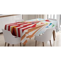 an image of a dining table set with colorful cloths on it and white chairs