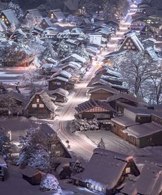 an aerial view of a snowy village at night with lights on the houses and trees