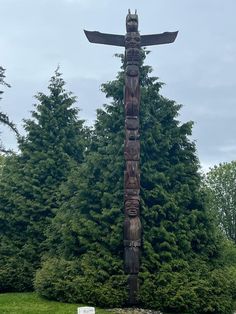 a wooden totema standing in front of some trees